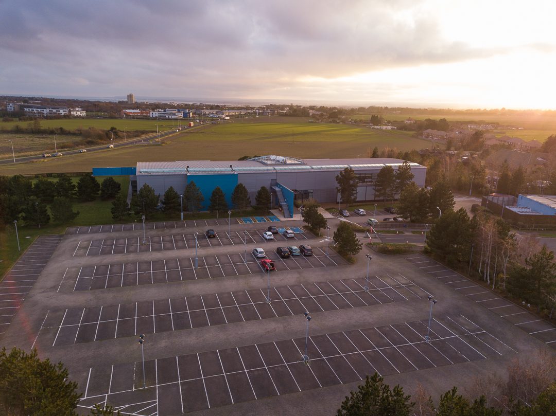 Aerial photograph at dusk looking across the site's car park toward the former Saga building